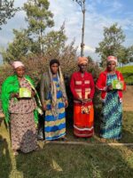 Four tea farmers standing together, with two holding boxes of Clipper Tea