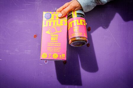 Little's Toffee Nut capsules and instant coffee products held up against purple background.